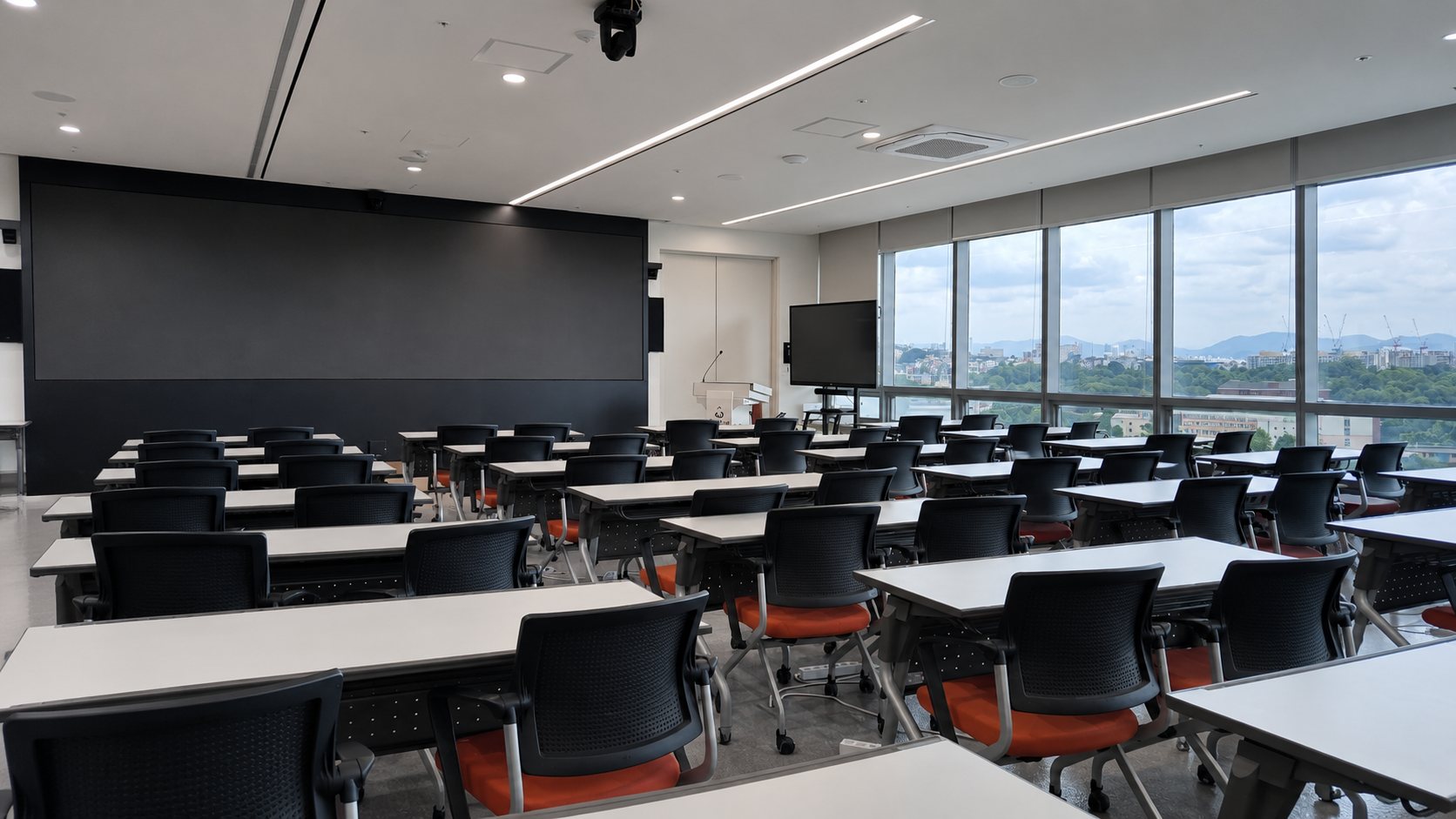 Large meeting room with a wide screen and floor-to-ceiling windows